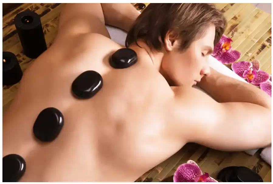 A soothing image depicting a pair of hot stones placed on a person's feet during a Hotstone Reflexology Massage session at Rangeela Massage Center.